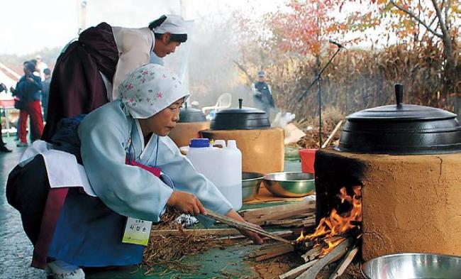 A woman cooks rice in a traditional way at a previous Icheon Rice Cultural Festival. (Icheon Rice Cultural Festival organizing committee)