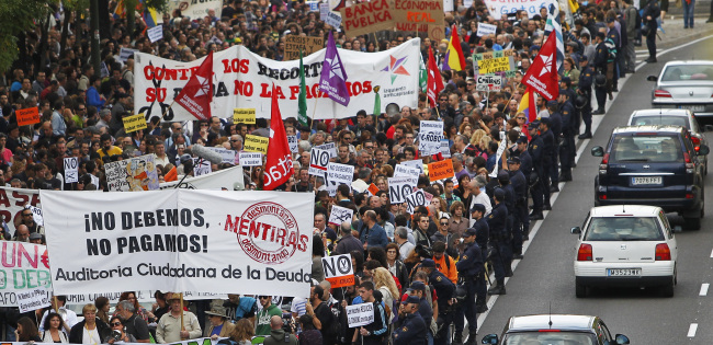 Protestor march as they hold banners reading “We don’t owe, we won’t pay” against austerity measures announced by the Spanish government in Madrid on Saturday. (AP-Yonhap News)