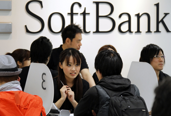 Softbank Corp. employees tend customers who purchased Apple’s new tablet device iPads at a Softbank store in Tokyo. (AP-Yonhap News)