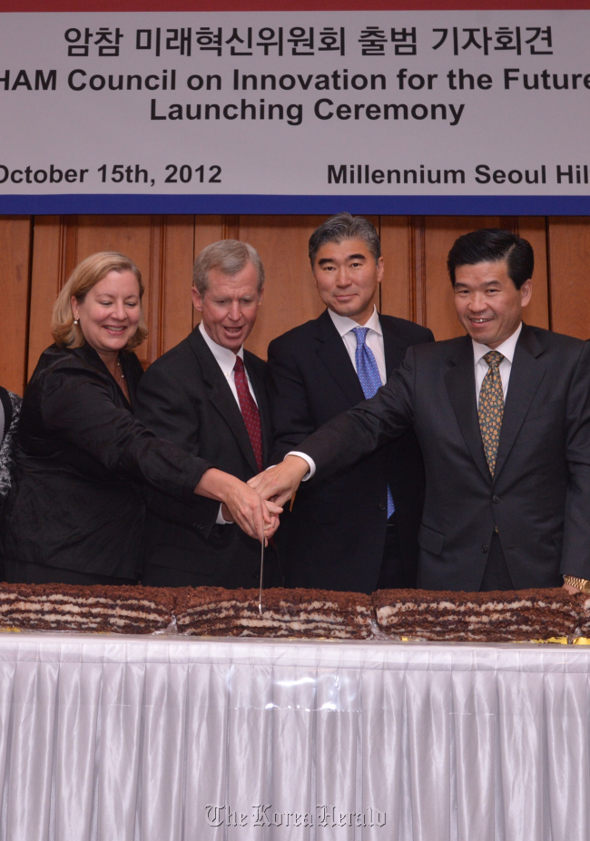 (From left) AMCHAM Korea President Amy Jackson, AMCHAM Korea chairman Pat Gaines, U.S. Ambassador Sung Kim, and James Kim, general manager and CEO of Microsoft Korea and inaugural chairman of the AMCHAM Council on Innovation for the Future, cut rice cakes at the council’s launch in a Seoul hotel on Monday. (Lee Sang-sub/ The Korea Herald)