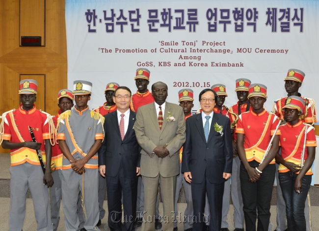 KBS president Kim In-kyu (third from left, front row), South Sudan’s Information Minister Barnaba Marial Benjamin (center) and Korea Eximbank CEO Kim Yong-hwan (fifth from left, front row) pose with a teenage brass band from the South Sudanese village of Tonj at KBS headquarters in Seoul on Monday. (Korea Eximbank)