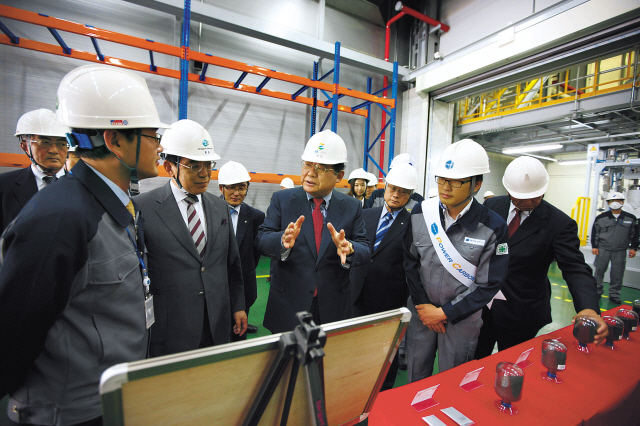 GS Caltex chairman Hur Dong-soo (third from left, gesturing) explains the production process of negative electrodes, a key material in rechargeable battery packs, to his VIP guests at the company’s production site in Gumi, NorthGyeongsang Province, in May. (GS Caltex)