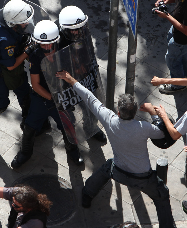 Protesters clash with riot police in Athens, during a 24-hour nationwide general strike on Thursday. ( AP-Yonhap News)