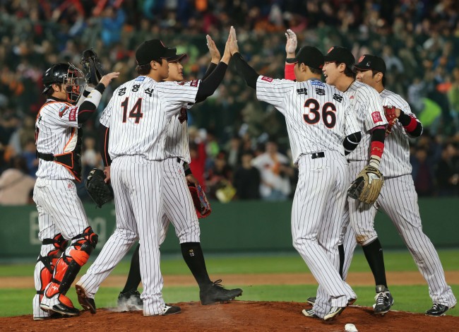 The Lotte Giants players celebrate after defeating the SK Wyverns 4-1 of the baseball playoff series on Friday. (Yonhap News)