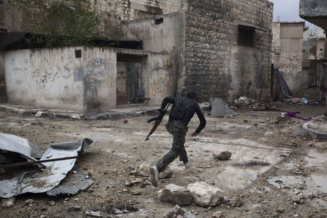 A Syrian rebel runs across a street to dodge sniper fire in the Karm al-Jabal district of the northern city of Aleppo on Monday. (AFP-Yonhap News)