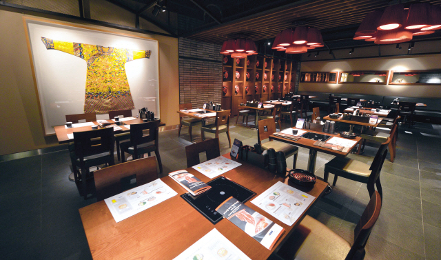 At Crystal Jade Hot Pot Restaurant, each table comes with its own sleek, built-in black electric stove. (Lee Sang-sub/The Korea Herald)