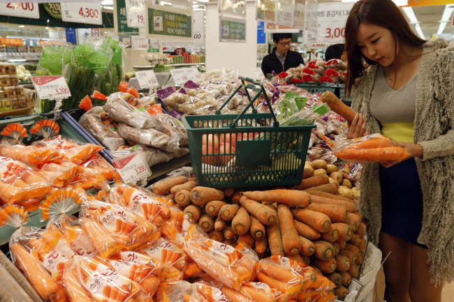 A shopper buys goods at a supermarket in Seoul. (Yonhap News)