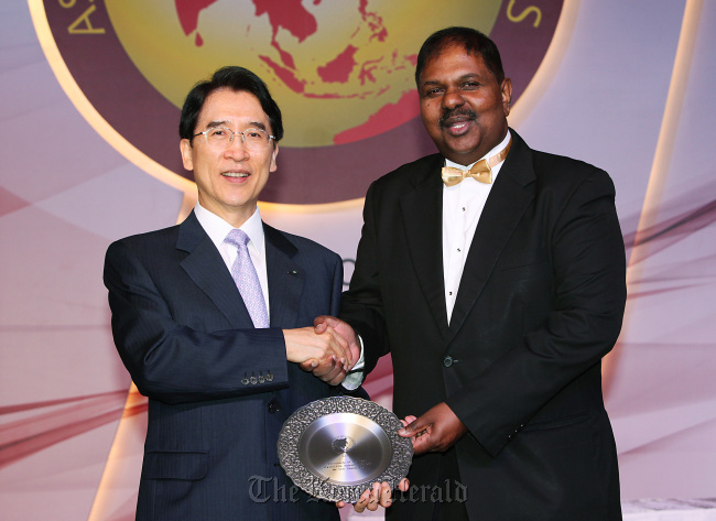 Kyobo Life Insurance chairman Shin Chang-jae (left) poses with Sivam Subramaniam, editor-in-cheif of Asia Insurance Review, after winning a top insurance award at a ceremony in Kuala Lumpur, Malaysia, on Sunday. (Kyobo Life Insurance)