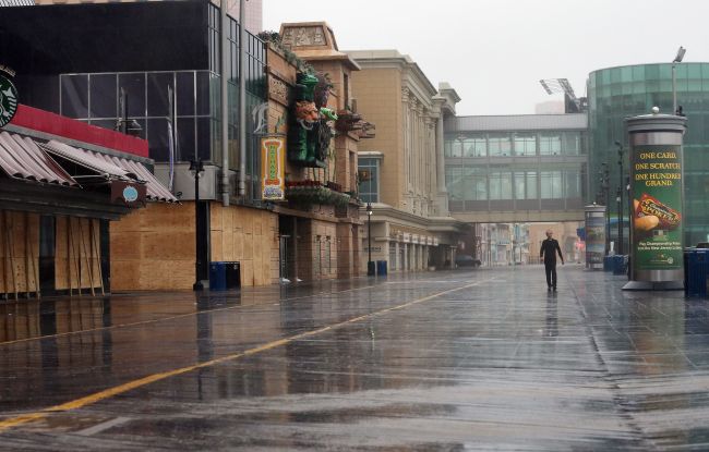 A man walks past boarded up structures on the boardwalk ahead of Hurricane Sandy on October 28, 2012 in Atlantic City, New Jersey. (AFP-Yonhap News)