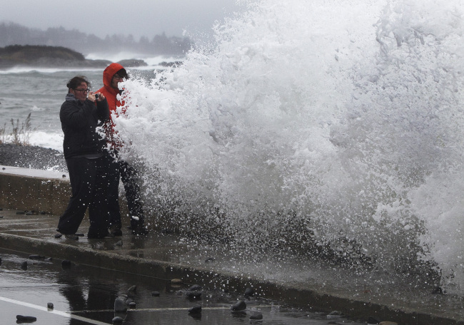 Lisa Famularo and her husband, Michael Green, prepare to get slammed by a large wave while making pictures of heavy surf in the Atlantic Ocean during the early stages of Hurricane Sandy, Monday, Oct. 29, 2012, in Kennebunk, Maine.(AP-Yonhap News)