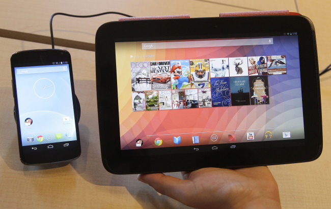 The Nexus 4 smartphone (left) and the Nexus 10 tablet are shown by Randall Safara of Google at a Google announcement in San Francisco on Monday. (AP-Yonhap News)