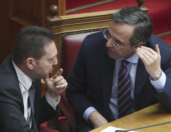 Greece’s Prime Minister Antonis Samaras (right) speaks with Greece’s Finance Minister Yannis Stournaras during a vote on a privatization bill at the Greek parliament in Athens on Wednesday. (AP-Yonhap News)