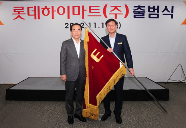 Lee In-won (left), vice chairman of Lotte Group’s policy headquarters, poses with Lotte Hi-mart chief executive Han Byeong-hee on Thursday at Lotte Hi-mart’s Seoul headquarters to mark the launch of the merged entity. (Yonhap News)