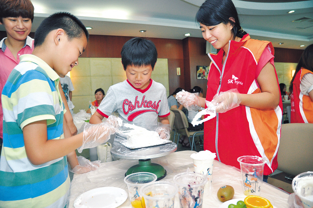 An SK Hynix official helps Chinese students invited by the company make a cake at its main factoryin Wuxi, Jiangsu Province, China. (SK Hynix)