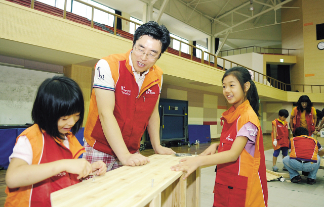 With his daughters, an SK Hynix official participates in furniture making at a gym in the company’smain factory in Icheon, Gyeonggi Province. (SK Hynix)