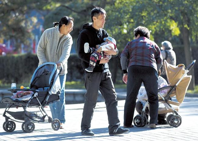 Chinese families bring their babies to the Ritan Park in Beijing. (AP-Yonhap News)