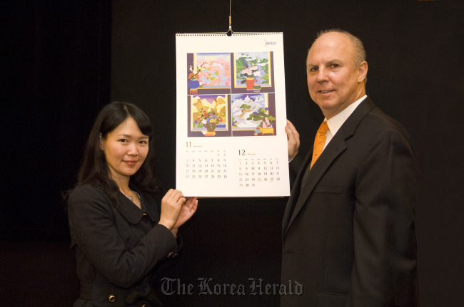 Merck Korea CEO Juergen Koenig (right) and artist Kim Ji-hye introduce the company’s 2013 calendar. (Merck Korea)