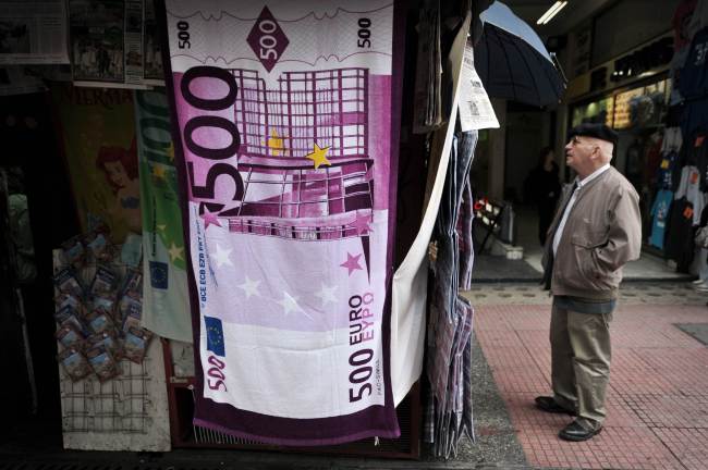 A man reads a newspaper’s headlines in Athens. (AFP-Yonhap News)