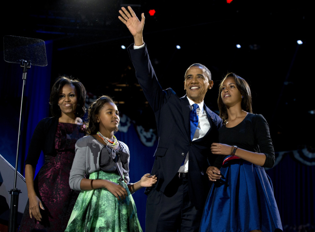 President Barack Obama waves as he walks on stage with first lady Michelle Obama and daughters Malia and Sasha at his election night party Wednesday. (AP-Yonhap News)