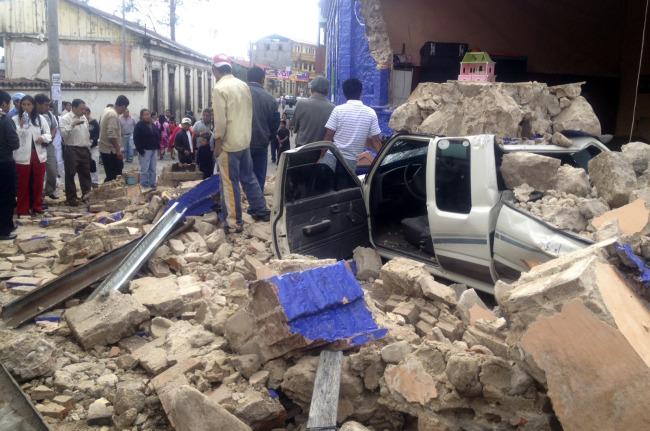 Photo provided by the radio La Red Deportiva shows residents standing near debris after an earthquake in San marcos, Guatemala, Wednesday. (Xinhua-Yonhap News)