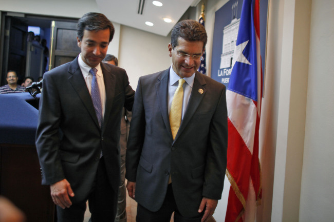 Pedro Pierluisi (right), Puerto Rico’s representative in U.S. Congress, is accompanied by Puerto Rico’s Gov. Luis Fortuno at the end of a news conference in San Juan, Puerto Rico, Wednesday. (AP-Yonhap News)
