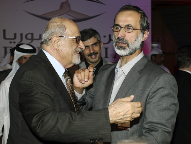 Syrian opposition figure and prominent Syrian human rights activist Haytham al-Maleh (left) congratulates Islamic preacher Moaz al-Khatib after he was elected president of the newly formed Syrian National Coalition for Opposition and Revolutionary Forces, in Doha, Qatar, Sunday. (AP-Yonhap News)