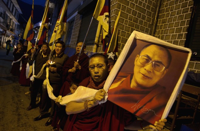 An exile Tibetan carries a portrait of the Tibetan spiritual leader the Dalai Lama during a candlelit vigil Dharmsala, India, Sunday. (AP-Yonhap News)