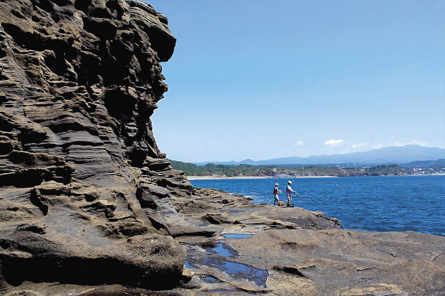 Two people fish off the coast of the Yongmeori, or dragon head, a tuff ring located in the far southwestern corner of Jeju Island. (Julie Jackson/The Korea Herald)