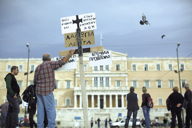 A demonstrator holds a banner outside the Greek parliament on Syntagma square in Athens on Nov. 7. (Bloomberg)