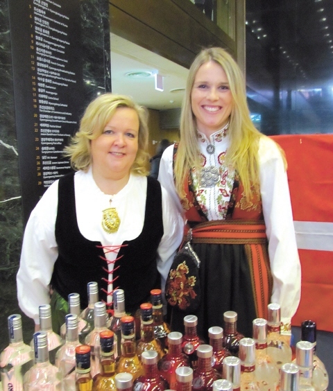 Hilkka Heimonen (left), wife of Finnish Ambassador to Korea Matti Heimonen, and Kristine Meeks, president of the Nordic Club and who is Norwegian, show off their traditional Scandinavian outfits behind an array of alcoholic beverages from Norway, Sweden and Finland during the 34th annual SIWA and Diplomatic Community Bazaar at the Seoul Museum of History on Tuesday.