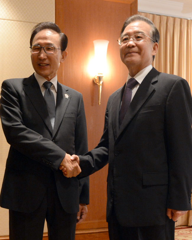 President Lee Myung-bak and Chinese Premier Wen Jiabao hold talks on the sidelines of the annual Association of Southeast Asian Nations summit in Phnom Penh on Monday. (Yonhap News)