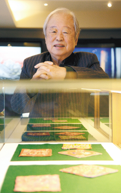 Huh Dong-hwa, director of the Museum of Korean Embroidery, poses for a photo in front of an embroidery display. (Ahn Hoon/The Korea Herald)