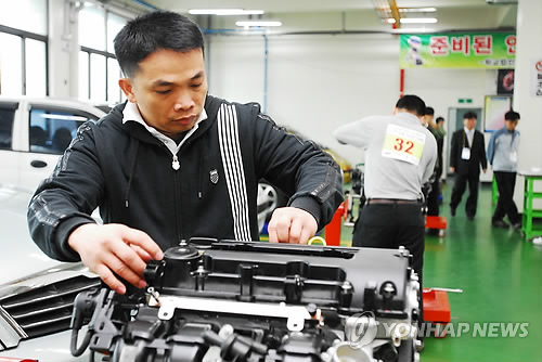 A foreign worker is fixing an engine. (Yonhap News)