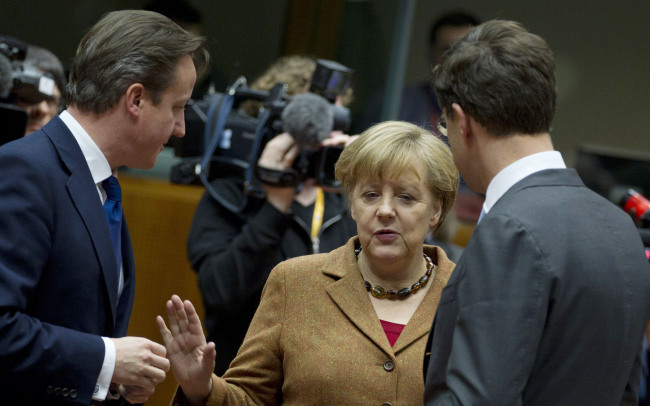 British Prime Minister David Cameron (left) speaks with German Chancellor Angela Merkel (center) and Dutch Prime Minister Mark Rutte during a round table meeting at an EU summit in Brussels on Thursday. (AP-Yonhap News)