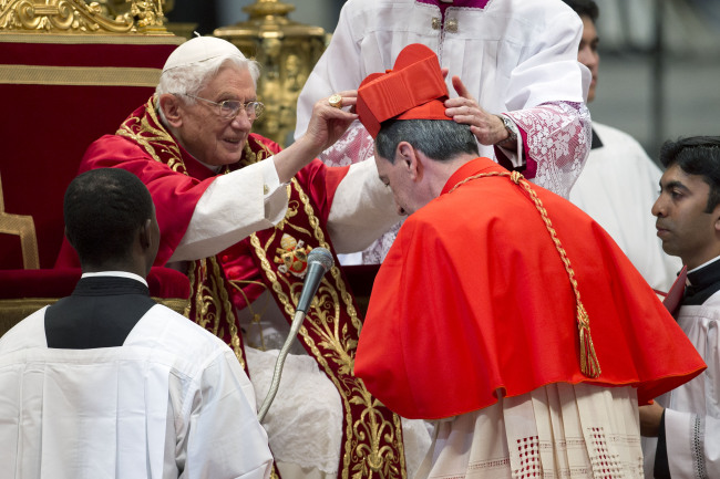 Newly elected Cardinal Ruben Salazar Gomez of Colombia (right) receives the red three-cornered biretta hat from Pope Benedict XVI during a consistory inside the St. Peter’s Basilica at the Vatican on Saturday. (AP-Yonhap News)