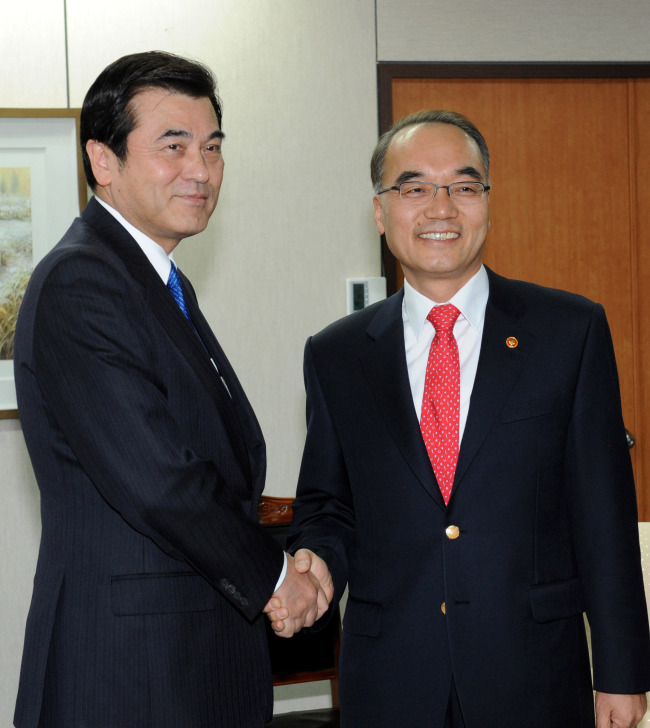 Korean Finance Minister Bahk Jae-wan (right) greets his Japanese counterpart Koriki Jojima at his office in Gwacheon, Gyeonggi Province, on Saturday. (Yonhap News)