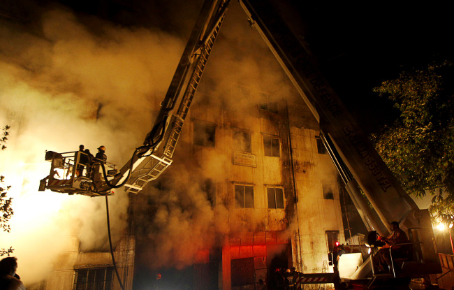 Bangladeshi firefighters battle a fire at a garment factory in the Savar neighborhood in Dhaka, Bangladesh, Saturday. (AP-Yonhap News)