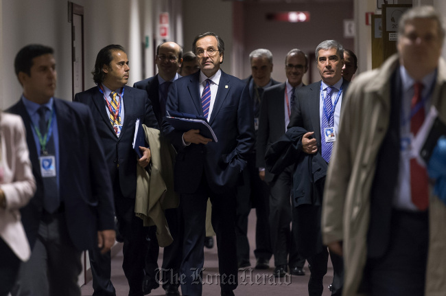 Antonis Samaras, Greece‘s prime minister (center) arrives to speak at a news conference following the European Union leaders summit meeting at the European Council headquarters in Brussels on Friday. (Bloomberg)