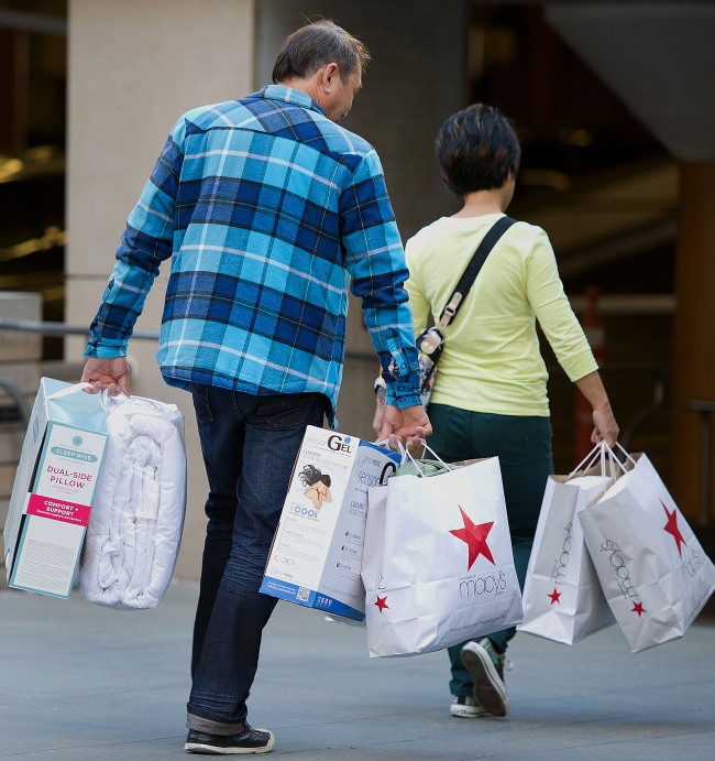 Customers carry Macy’s Inc. shopping bags in San Francisco on Friday. (Bloomberg)