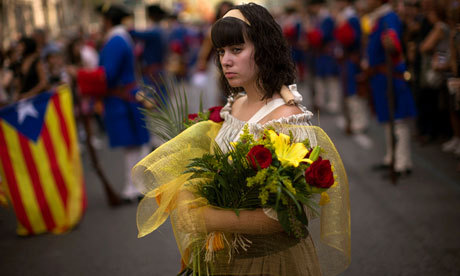 A woman dressed in traditional Catalan costume holds flowers to be laid at the monument of a leader killed during the fall of Barcelona in 1714. (AP)