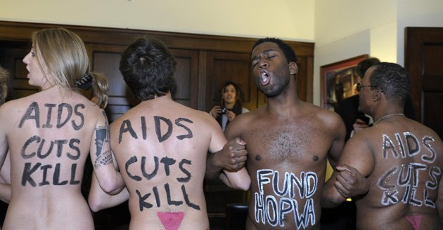 Naked AIDS activists, with painted slogans on their bodies, protest inside the lobby of the Capitol Hill office of House Speaker John Boehner of Ohio, Tuesday, Nov. 27, 2012. (AP)