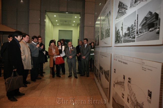 Portuguese Ambassador to Korea Antonio Quinteiro Nobre (fourth from right) listens to a tour guide during the exhibition opening of “Eduardo Souto de Moura Competitions: 1979-2010” at Yonsei University’s Atrium Hall on Monday. (Portuguese Embassy)