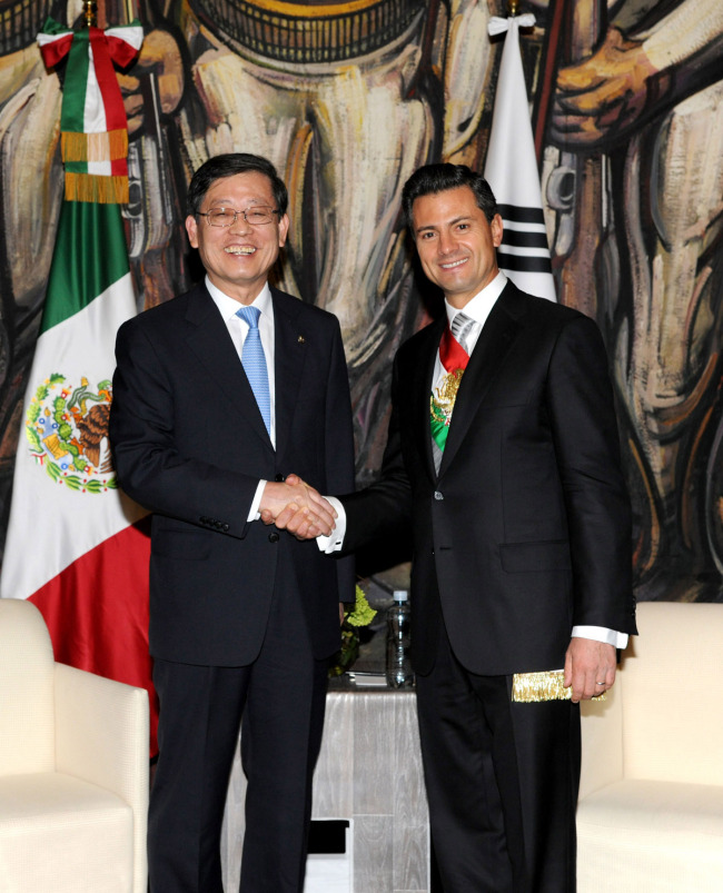 Korea’s Prime Minister Kim Hwang-sik (left) shakes hands with Mexico’s newly sworn-in President Enrique Pena Nieto in Mexico City on Saturday. (Yonhap News)