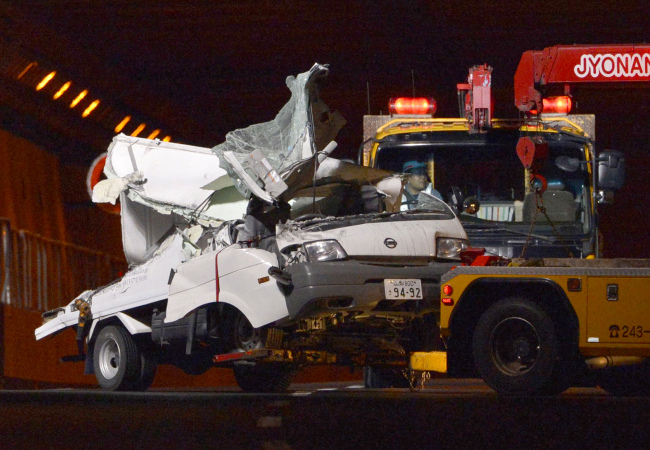 A tow truck hauls the wreckage of a truck, which was crushed in Sunday’s accident, out of the Sasago Tunnel on the Chuo Expressway in Koshu, Yamanashi Prefecture, Japan, Monday. ( AP-Yonhap News)