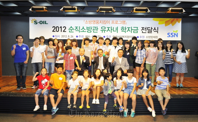 S-Oil CEO Nasser Al-Mahasher (third from left, second row) poses with children of fallen firefighters in a ceremony to award scholarships, held at the company’s head office in Mapo, Seoul, on Aug. 28. (S-Oil)