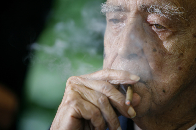 Brazil’s star architect Oscar Niemeyer smokes during his 100th birthday celebration in Rio de Janeiro, Brazil. ( AP-Yonhap News)