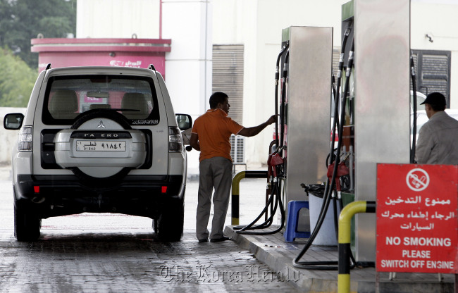 In this Dec. 1 photo, a man fills up his tank at a gas station in Doha, Qatar. The host of the current U.N. climate talks, Qatar is among dozens of nations that keep gas prices low through subsidies that exceeded $500 billion globally last year. (AP-Yonhap News)