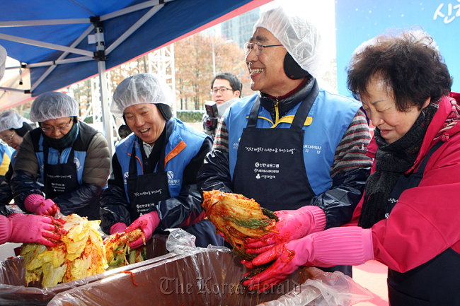 Shinhan Financial Group chairman Han Dong-woo (second from right) makes kimchi with the chief executives of affiliated companies on Thursday at Seoul’s Cheonggye Plaza. (Shinhan Financial Group)