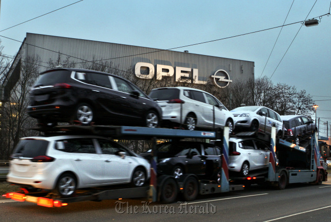 A car transporter loaded with automobiles leaves the General Motor Co.’s Opel plant in Bochum. (Bloomberg)