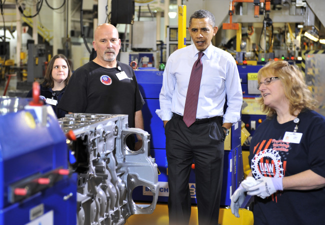 President Barack Obama listens as Cindy Burtis (right) talks about the plant operations with Tom Percha (left) at Detroit Diesel in Redford on Monday. (AP-Yonhap News)